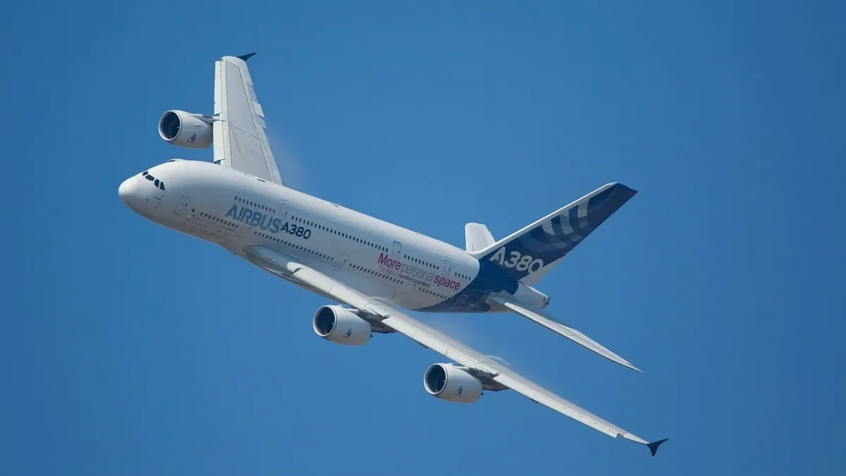 An Airbus A380 commercial jet airliner flying in a clear blue sky.