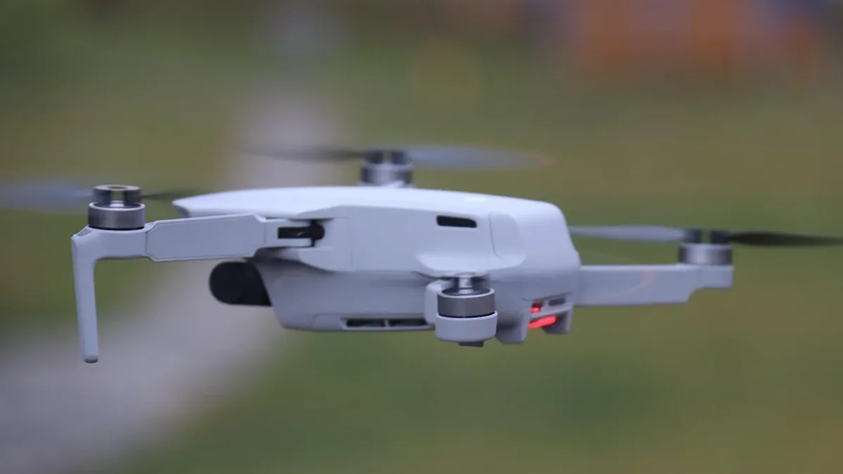 A small white drone flying in the air, with its propellers spinning and a red light visible on its front.